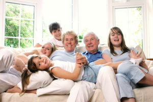 Grandparents sitting with grandchildren on sofa