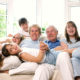 Grandparents sitting with grandchildren on sofa